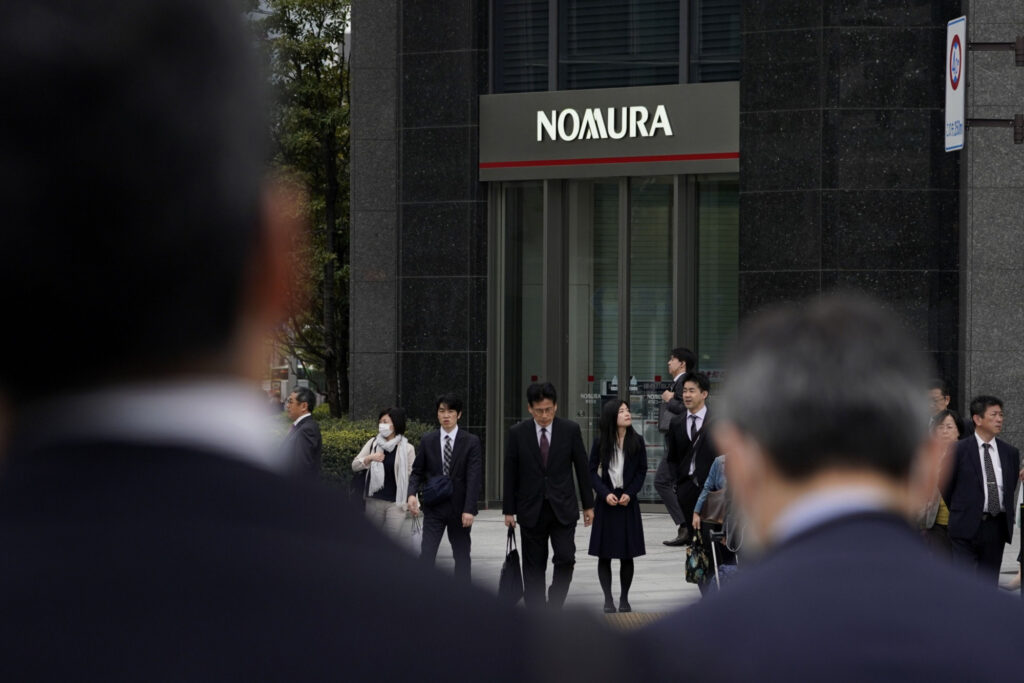 Pedestrians stand in front of Nomura Holdings Inc., in Tokyo, Japan. Photo: Toru Hanai, Bloomberg