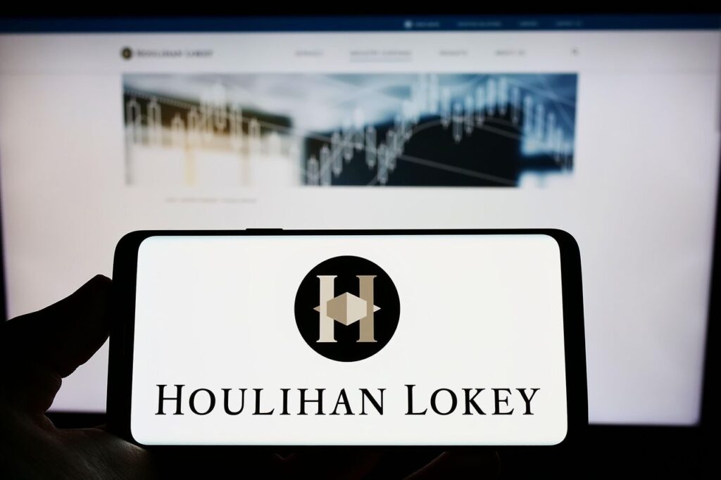 Smartphone with logo of US investment company Houlihan Lokey Inc. on screen in front of website. Photo: Getty Images