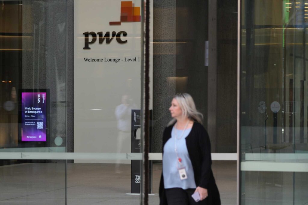 Pedestrian walks out of the offices of PricewaterhouseCoopers (PwC) in Sydney, Monday, May 29, 2023. Photo, Rick Rycroft