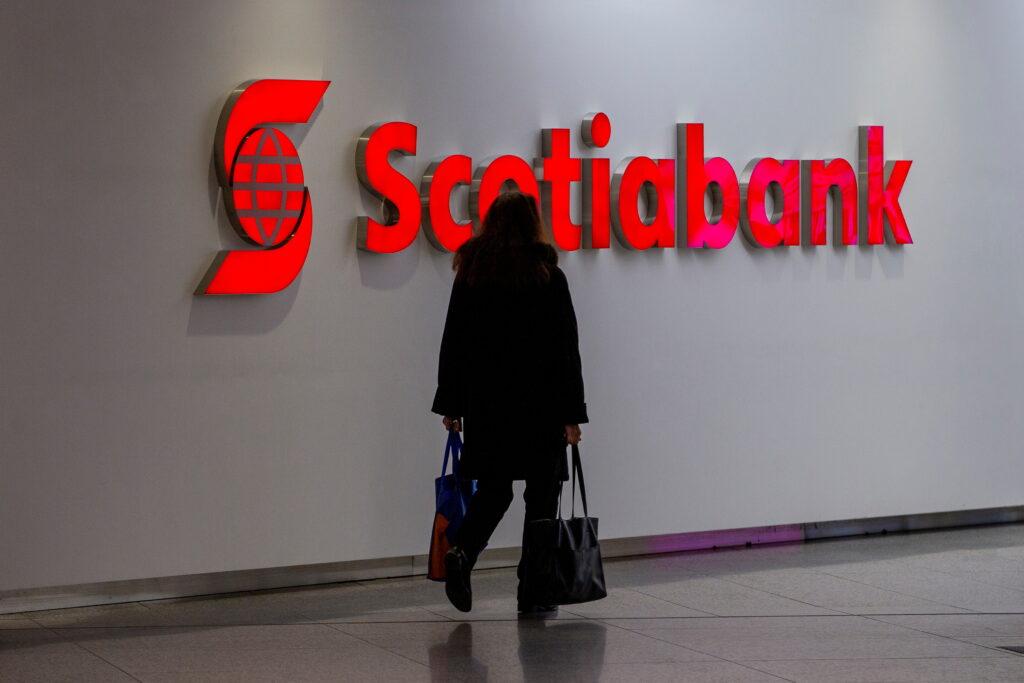 A person walks infant of a sign for The Bank of Nova Scotia, operating as Scotiabank, in Toronto. Photo: Getty Images