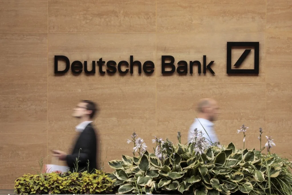 Pedestrians pass the offices of Deutsche Bank in London. PHOTO: Jason Alden/Bloomberg